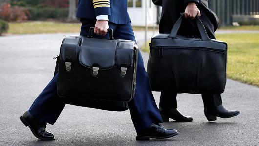 A military aide carries the so-called "nuclear football," which contains launch codes for the U.S. nuclear arsenal and which travels with the sitting U.S. president, to depart with U.S. President Donald Trump for travel to Utah from the White House in Washington, U.S. December 4, 2017.