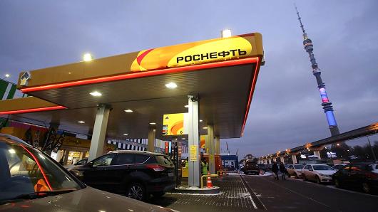 An illuminated Rosneft oil company logo sits on the roof of an OAO Rosneft gas station near the Ostankino TV tower displaying the colors of the Russian national flag in Moscow, Russia, on Tuesday, Dec. 2, 2014.