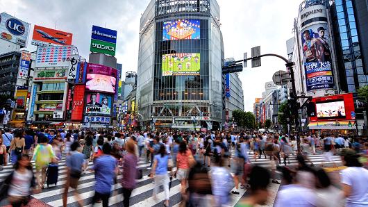 Motion blur of busy pedestrians walking at famous Shibuya Crossing, Tokyo, Japan