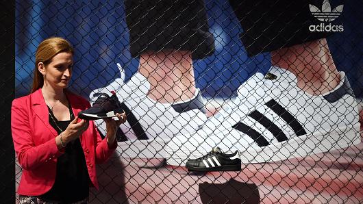 The employee of Adidas Elisabeth Koelemij Peters, poses with a shoe of the German sportswear giant prior the shareholders meeting of the German sportswear giant Adidas.