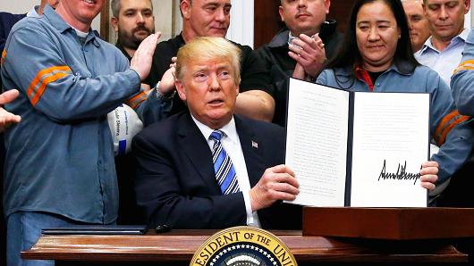 President Donald Trump holds up a proclamation during a White House ceremony to establish tariffs on imports of steel and aluminum at the White House in Washington, March 8, 2018.