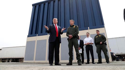 President Donald Trump talks with a U.S. Customs and Border Protection (CBP) Border Patrol Agent while participating in a tour of U.S.-Mexico border wall prototypes near the Otay Mesa Port of Entry in San Diego, California, March 13, 2018.