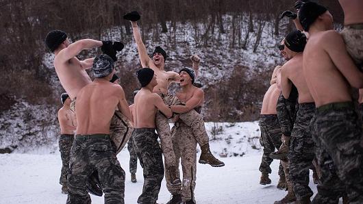 South Korean and US soldiers wrestle for photographers during a joint annual winter exercise in Pyeongchang, on January 28, 2016.