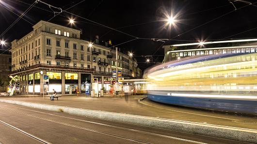 A tramway car captured with blurred motion rushes through the Paradeplatz (Parade square) in the heart of Switzerland banking industry in Zurich at night.