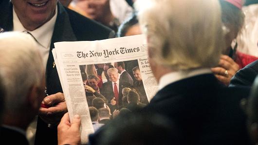 Donald Trump views a photo of himself on the cover of The New York Times during an RNC goodbye reception at the Westin Hotel in Cleveland, on Friday, July 22, 2016.