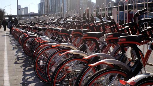 Mobike bicycles are seen in line at a docking area along a pedestrian sidewalk at the Central Business District (CBD) in Beijing, March 27, 2017.