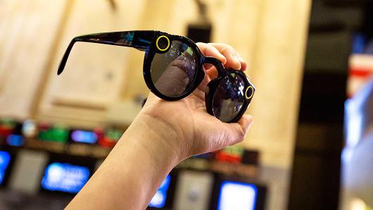 A person holds up a pair of Snapchat Spectacles by Snap Inc. on the floor of the New York Stock Exchange (NYSE) during the company's initial public offering (IPO) in New York, March 2, 2017.