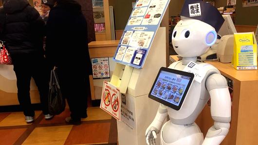 Pepper, a humanoid robot developed by SoftBank Group Corp., moves around on its own to guide passengers at sushi shop in Tokyo, Japan.