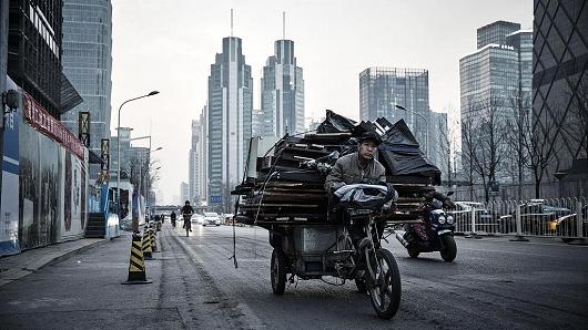 A man rides a bicycle rickshaw carrying scrap materials in Beijing, China, on Wednesday, March 2, 2016.