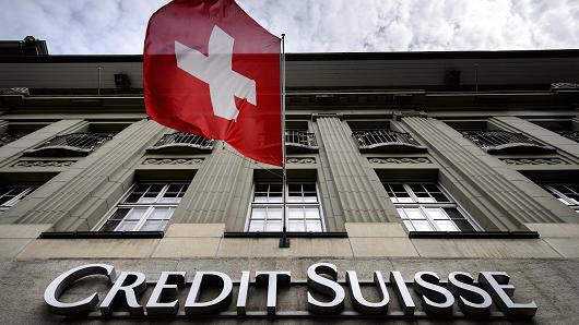 A Swiss flag flies over a sign of Swiss bank Credit Suisse on May 8, 2014 in Bern.