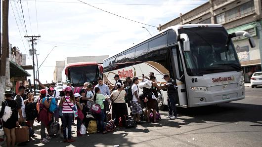 Migrants in a caravan of Central American asylum-seekers board buses in Mexicali, Mexico, Thursday, April 26, 2018, for a two-hour drive to Tijuana to join up with about 175 others who already arrived.