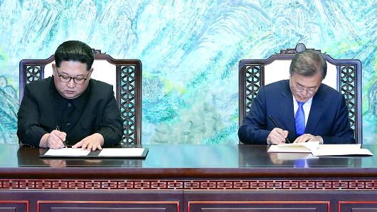 South Korean President Moon Jae-in and North Korean leader Kim Jong Un sign documents at the truce village of Panmunjom inside the demilitarized zone separating the two Koreas, South Korea, April 27, 2018.