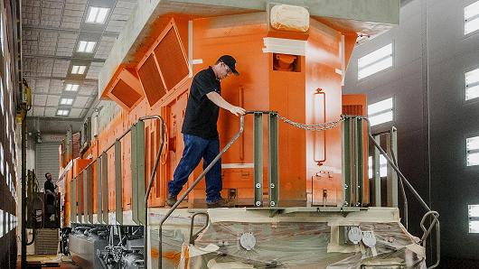 An employee preps a diesel locomotive for painting at the General Electric Manufacturing Solutions facility in Fort Worth, Texas.