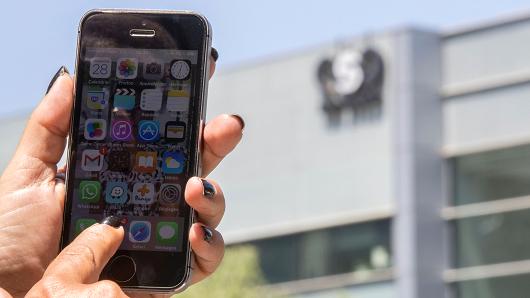 An Israeli woman uses her iPhone in front of the building housing the Israeli NSO group, on August 28, 2016, in Herzliya, near Tel Aviv. Apple iPhone owners, were urged to install a quickly released security update after a sophisticated attack on an Emirati dissident exposed vulnerabilities targeted by cyber arms dealers.