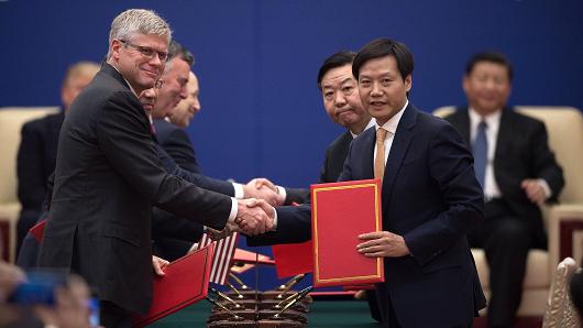 Lei Jun, the CEO of Chinese smartphone maker Xiaomi (front right), shakes hands with Qualcomm CEO Steven Mollenkopf on November 9, 2017, after signing a memorandum of understanding during a ceremony attended by President Donald Trump (obscured) and China's President Xi Jinping (back right) at the Great Hall of the People in Beijing.