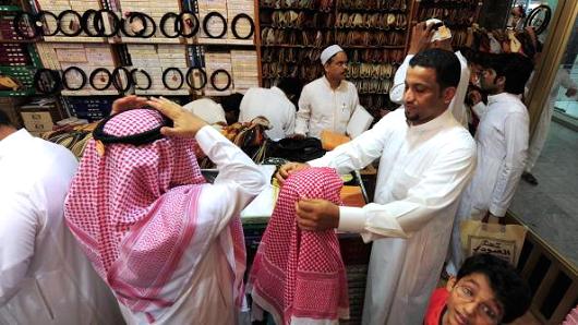 Saudi men shop with their children at a mall in Jeddah late on September 17, 2009 ahead of celebrations for Eid al-Fitr.