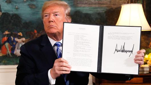 President Donald Trump displays a presidential memorandum after announcing his intent to withdraw from the JCPOA Iran nuclear agreement in the Diplomatic Room at the White House in Washington, May 8, 2018.