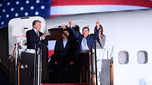 US President Donald Trump (L) applauds as US detainee Kim Dong-chul (2nd R) gestures upon his return with Kim Hak-song (C) and Tony Kim (behind) after they were freed by North Korea, at Joint Base Andrews in Maryland on May 10, 2018.