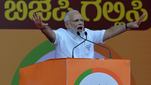 Indian Prime Minister Narendra Modi gestures to supporters during an election campaign rally in Bangalore on May 3, 2018.