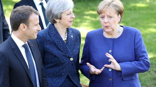 French President Emmanuel Macron (L), Britain's Prime Minister Theresa May (C) and German Chancellor Angela Merkel take a moment to discuss as they walk together during an EU-Western Balkans Summit in Sofia on May 17, 2018.