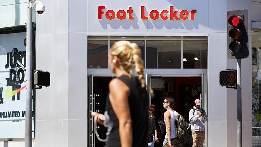 Shoppers and pedestrians pass in front of a Foot Locker store on the Third Street Promenade in Santa Monica, California.