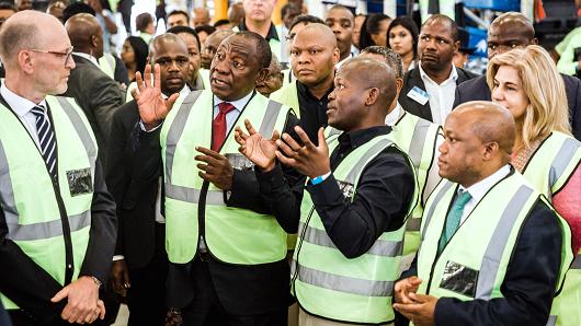 South Africa's President Cyril Ramaphosa (second left) speaks with workers during a visit to a Volvo assembly plant in Durban on May 19, 2018.