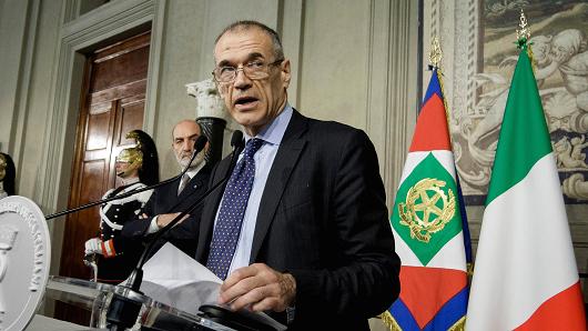 Italy's designated Prime Minister Carlo Cottarelli talks to journalists after having received from Italy's President Sergio Mattarella the mandate to form a new government at the Quirinale Palace.