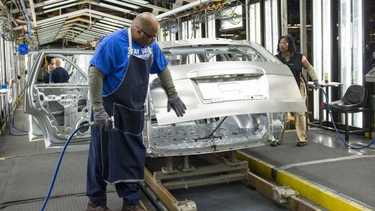 An employee uses a flash grinder to smooth out the frame of a sports utility vehicle at the General Motors assembly plant in Arlington, Texas.