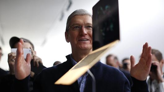 Apple CEO Tim Cook stands in front of an MacBook on display after an Apple special event at the Yerba Buena Center for the Arts on March 9, 2015 in San Francisco, California.