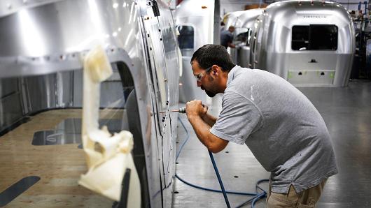 A factory worker installs rivets on an Airstream RV travel trailer at the company's assembly plant in Jackson Center, Ohio.