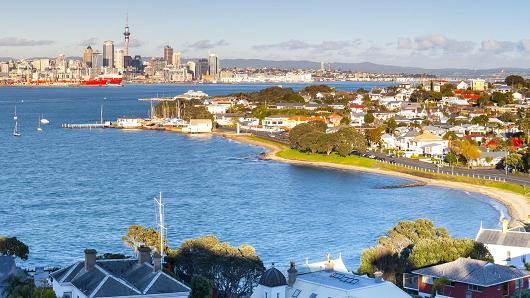 New Zealand, Auckland, Waitakere Harbour, Elevated View over Devenport towards CBD with Sky Tower at dawn