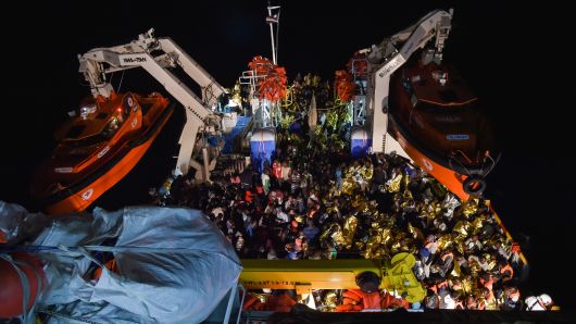 Migrants and refugees are transferred from the Topaz Responder ship run by Maltese NGO 'Moas' and the Italian Red Cross to the Spanish war ship Navarra, after being rescued off the coast of Libya on November 5, 2016.