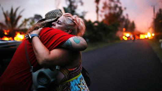 Zivile Roditis hugs Howie Rosin (L), shortly after Roditis' home was destroyed by lava from a Kilauea volcano fissure, in Leilani Estates, on Hawaii's Big Island, on May 25, 2018 in Pahoa, Hawaii.