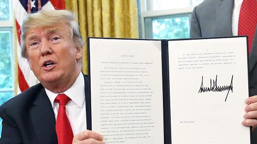 President Donald Trump displays an executive order he signed that will end the practice of separating family members who are apprehended while illegally entering the United States on June 20, 2018 in Washington, DC.