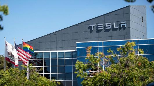 Flags fly outside of a Tesla building in Fremont, California.