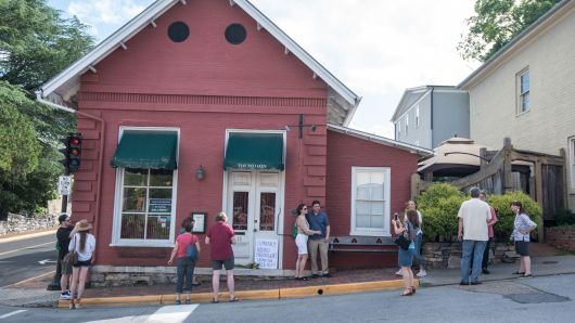 Passersby gather to take photos in front of the Red Hen Restaurant, Saturday, June 23, 2018, in Lexington, Va.