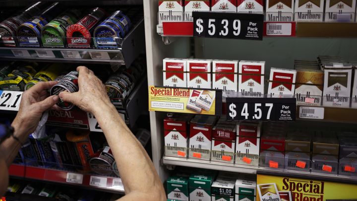 An employee stocks cans of tobacco beside a display of Marlboro brand cigarettes inside a tobacco store in Nashville, TN. 
