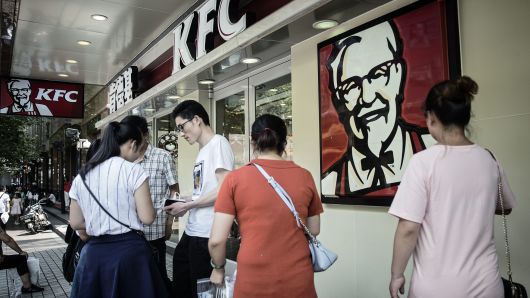 Pedestrians walk past a KFC restaurant in Shanghai, China.