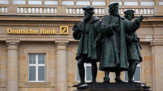 Statues stand outside a Deutsche Bank AG branch in Frankfurt, Germany.
