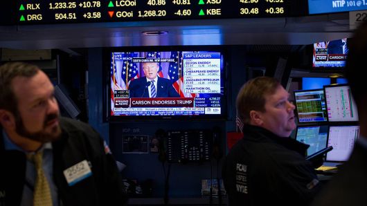 Donald Trump is seen speaking on a monitor as traders work on the floor of the New York Stock Exchange (NYSE) in New York, U.S., on Friday, March 11, 2016.