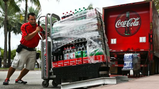 An employee delivers cases of Coca-Cola Co. brand soda in Miami Beach, Florida.