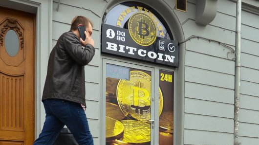 A man passes in front of a Bitcoin exchange shop in Krakow, Poland.