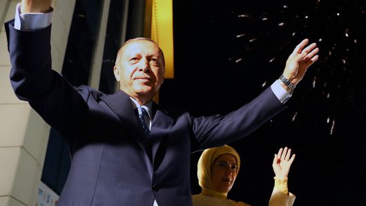 President of Turkey Tayyip Erdogan (L) and his wife Emine Erdogan (R) greet the crowd from the balcony of the ruling AK Party's headquarters as fireworks illuminate the sky following his election success in presidential and parliamentary elections in Ankara, Turkey on June 25, 2018. 