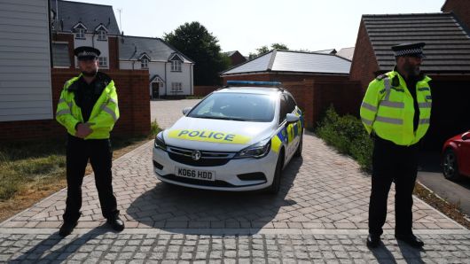 Police officers are seen standing guard outside a residential address in Amesbury, southern England, on July 5, 2018 where police reported a man and woman were found unconscious in circumstances that sparked a major incident after contact with what was later identified as the nerve agent Novichok.