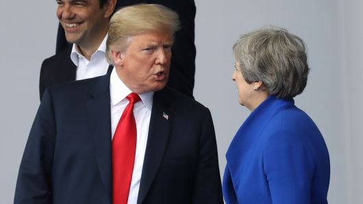 U.S. President Donald Trump, left, speaks with Theresa May, U.K. prime minister, as world leaders gather for a family photograph during the North Atlantic Treaty Organization (NATO) summit at the military and political alliance's headquarters in Brussels, Belgium, on Wednesday, July 11, 2018. 