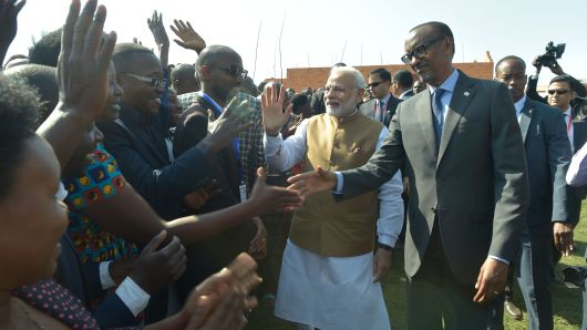 Indian Prime Minister Narendra Modi (C) and Rwandan President Paul Kagame (R) greet locals at the Rweru Model Village in Rwanda on July 24, 2018.
