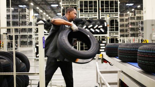 A worker loads automotive tires onto a conveyor belt at the Continental Tire Sumter plant distribution warehouse in Sumter, South Carolina.