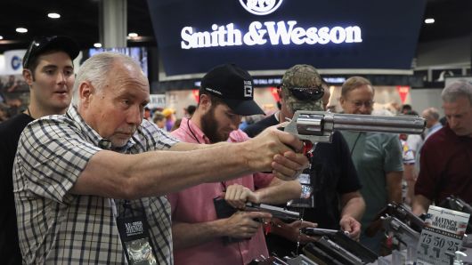 National Rifle Association members look over pistols in the Smith & Wesson display at the 146th NRA Annual Meetings & Exhibits on April 29, 2017 in Atlanta, Georgia.