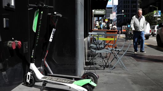 Bird and Lime scooters sit parked in front of a building on April 17, 2018 in San Francisco, California.