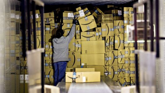 An employee unloads a truck load of Amazon.com packages at the United Parcel Service (UPS) Chicago Area Consolidation Hub in Hodgkins, Illinois.